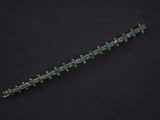 a close up of a green bracelet on a black surface