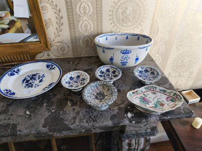 de nombreuses assiettes et bols posés sur une table, avec un miroir en arrière-plan