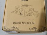 an electric nail drill set in a box sitting on a table