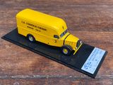 un petit camion jaune en plastique exposé sur une table