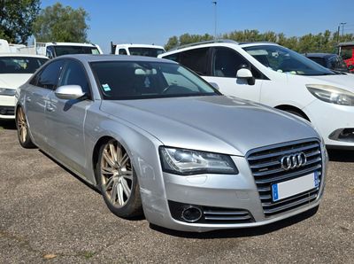 a silver audi parked in a parking lot with other cars in the background
