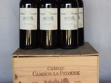 quatre bouteilles de vin dans un coffret en bois posé sur une table