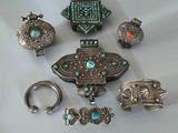 Plusieurs bijoux en argent et en turquoise sont exposés sur un fond blanc