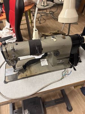 une machine à coudre posée sur une table dans une pièce