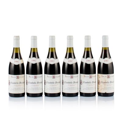 six bottles of wine are lined up on a white surface