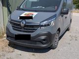 La camionnette est garée sur le bord de la route, devant un immeuble.