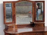 someone is taking a picture of their reflection in the mirror of a dressing table