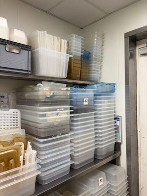 many plastic containers on the shelves in the room