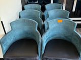 quatre chaises en velours bleu alignées devant une fenêtre