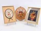 trois photos de fleurs encadrées sont exposées dans une vitrine