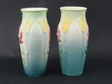 two vases sitting side by side on a black background