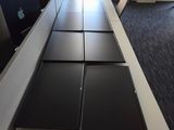a long table with four laptops on it in a room