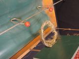 a green board with a rope and two red balls on it