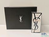 Eau de toilette Yves Saint Laurent en vaporisateur, dans un coffret noir, à côté d'un autre coffret noir orné d'un logo YSL blanc