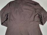 the back of a jacket hanging on a hanger on a wall