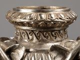 a silver vase with a handle and two birds on it