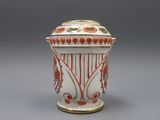 un vase blanc et rouge posé sur une surface grise