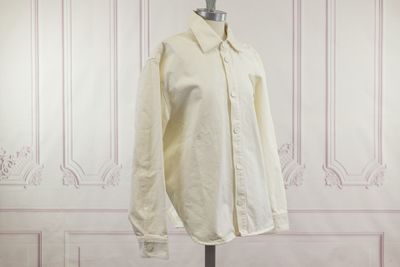 une photo d'une chemise blanche posée sur un présentoir pour mannequin