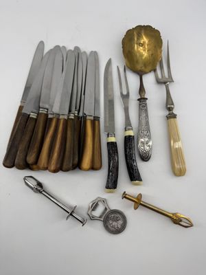 many different types of knives and spoons on the table