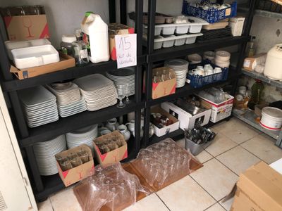 many plates and bowls on the shelves in the kitchen
