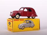 une petite voiture rouge posée sur une boîte jaune