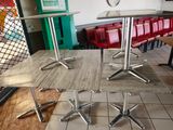 tables and chairs in a restaurant with a clock on the wall