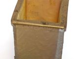 a small square vase with a gold rim sitting on a white surface