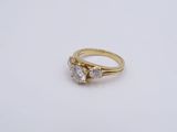 a close up of a gold ring with three diamonds on a white surface