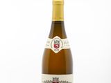 the bottle of white wine is sitting on a white surface