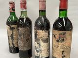 four bottles of wine are lined up in a row on a white surface