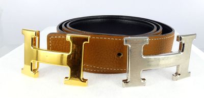 a brown belt with a gold h buckle on it