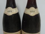 two bottles of wine sitting next to each other on a table