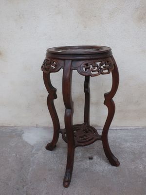 a small wooden table with a plant on top of it