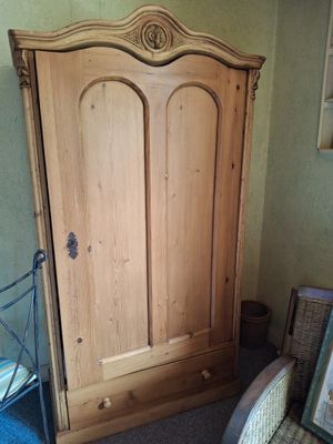 une armoire placée dans un coin de la pièce, avec une chaise devant