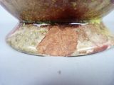 a close up of a vase with a brown and green design
