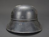 an old metal helmet on a gray background with a small hole in the center