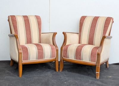 pair of striped upholstered chairs in a room with a white wall
