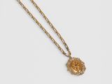 a gold necklace with a medallion pendant on a chain