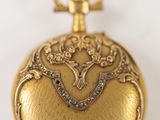 une image représentant une montre de poche en or sur laquelle figure un oiseau