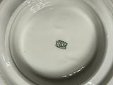 a close up view of a white bowl with a green logo on it
