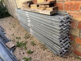 a stack of wooden boards on the ground next to a brick wall
