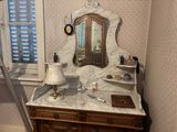a vanity with a mirror and a lamp in the corner