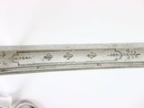 a silver knife with writing on it sitting on a table