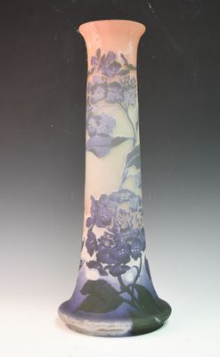 un vase avec des fleurs peintes dessus, posé sur une table