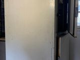 a refrigerator in the middle of a room with a window