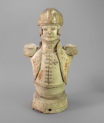 une vieille statue représentant un homme coiffé d'un chapeau