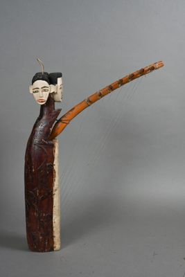 wooden figurine of a woman holding a bamboo stick and wearing a hat