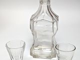 two glasses and a decanter sitting on a table