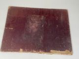 an old book on a white table with a red cover