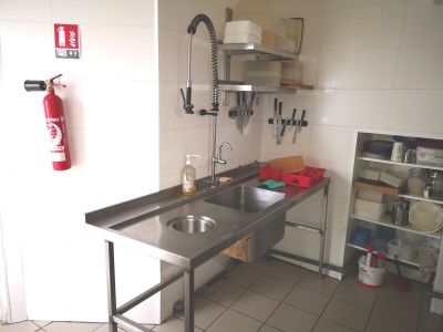 une cuisine équipée d'un évier, d'une cuisinière et d'un extincteur